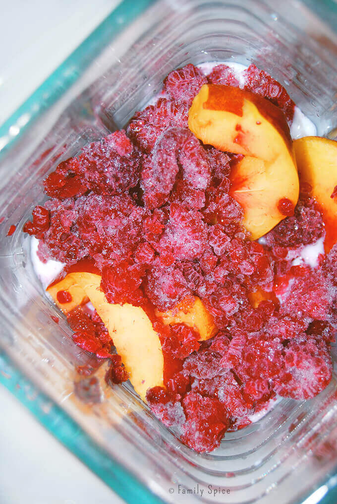 Frozen berries and nectarines in a blender for smoothie popsicles by FamilySpice.com