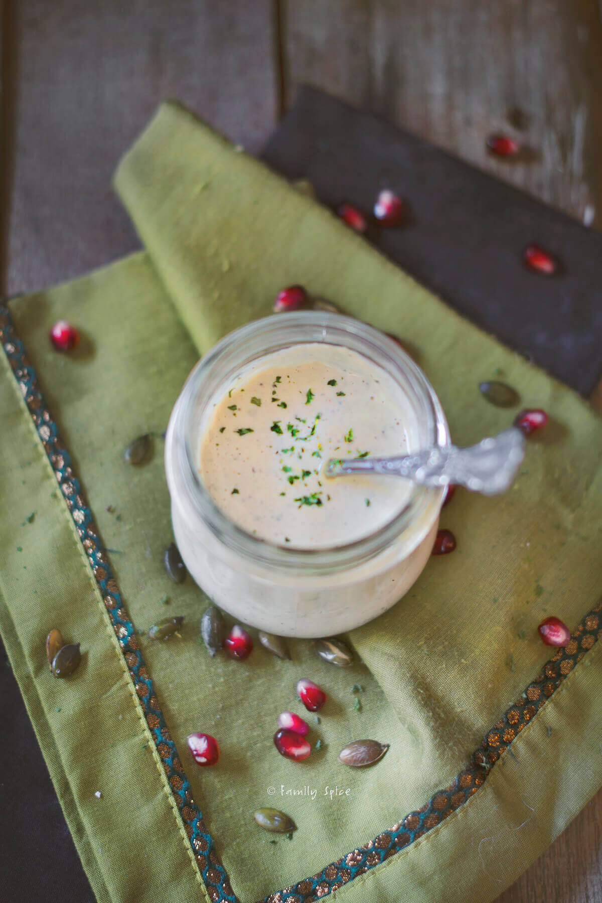 A small jar of homemade Casear dressing on a green cloth napkin