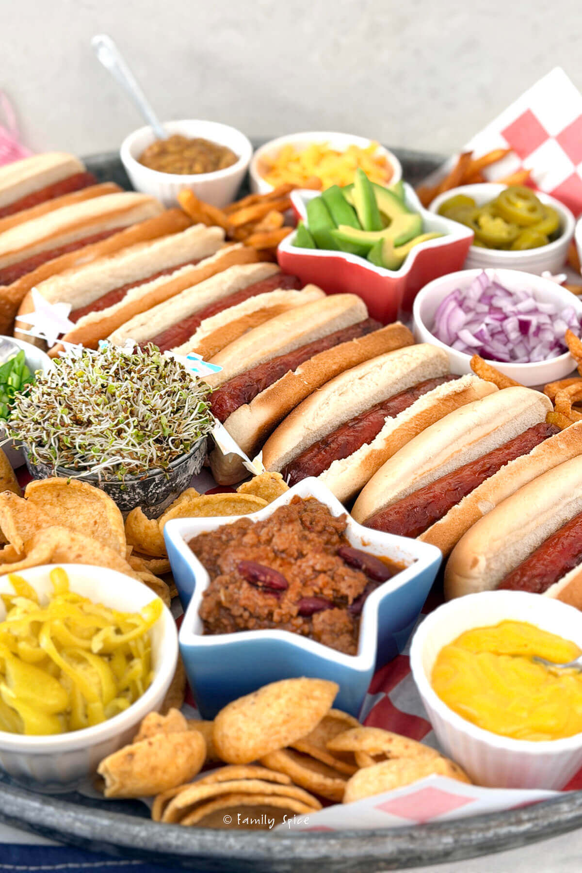 Closeup of items on a hot dog board, including hot dogs and various toppings.
