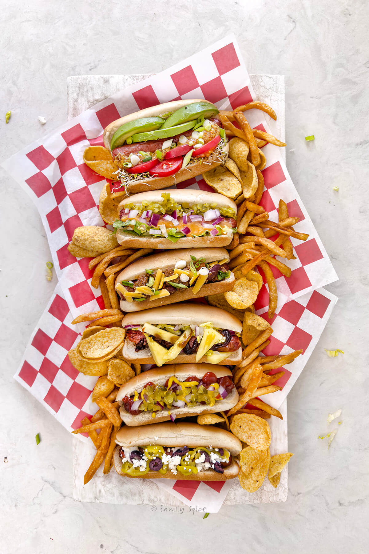A tray holding various hot dogs each with different types of flavors and hot dog toppings.