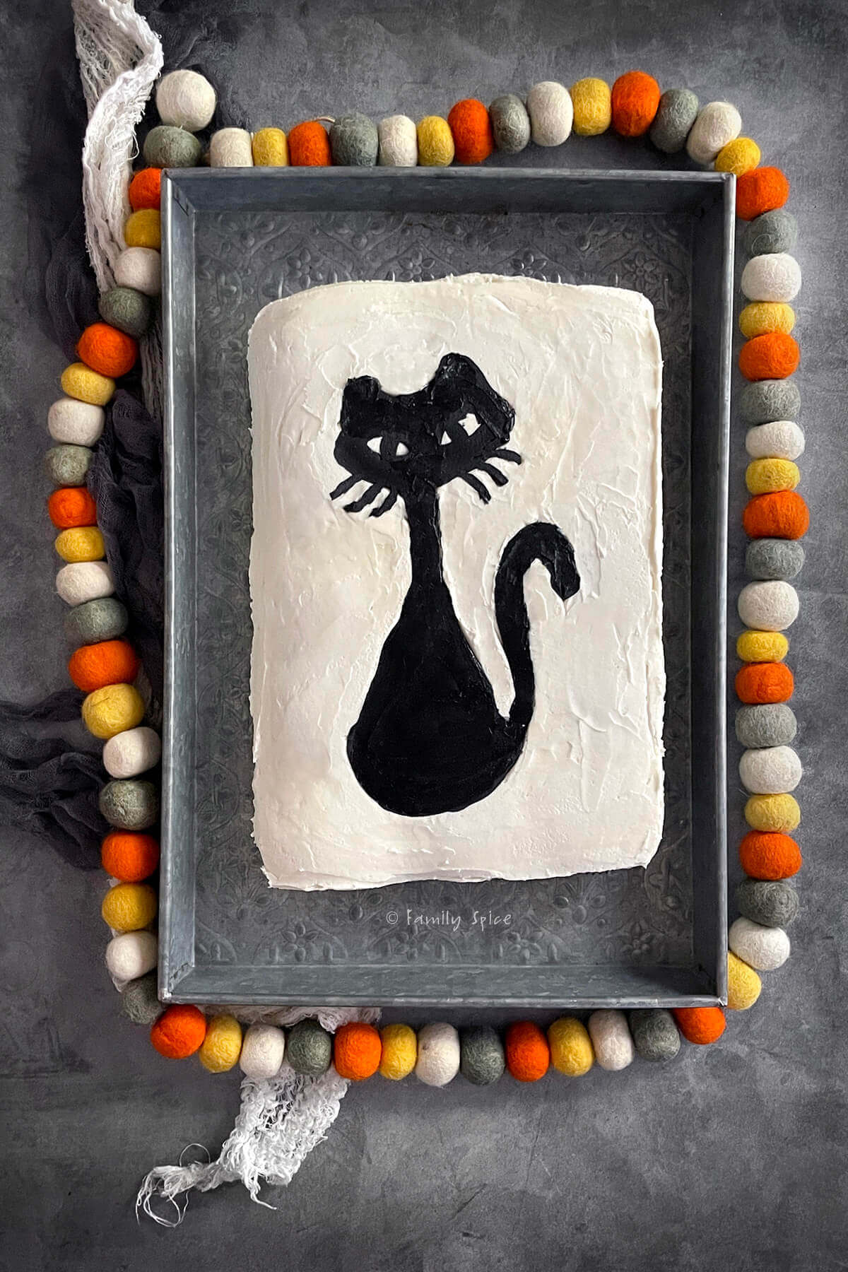 Top view of a halloween pull apart cupcake cake frosted white with a black cat.