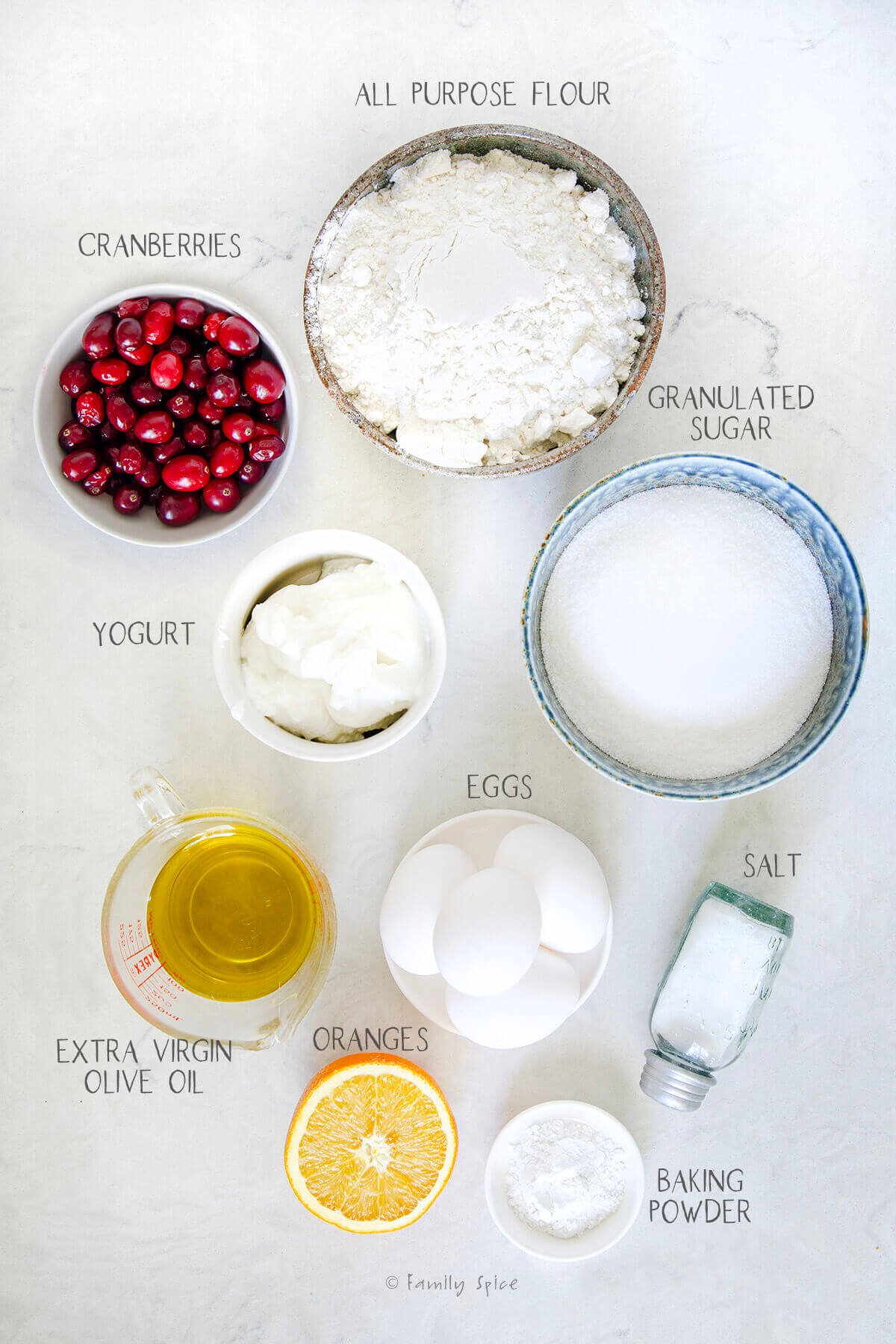 Ingredients labeled and needed to make an olive oil orange cranberry cake.