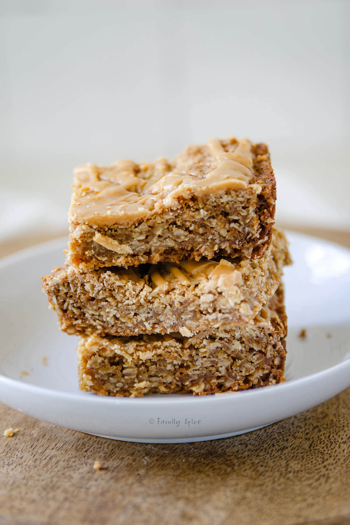 Closeup of a stack of 3 butterscotch bars on a plate.