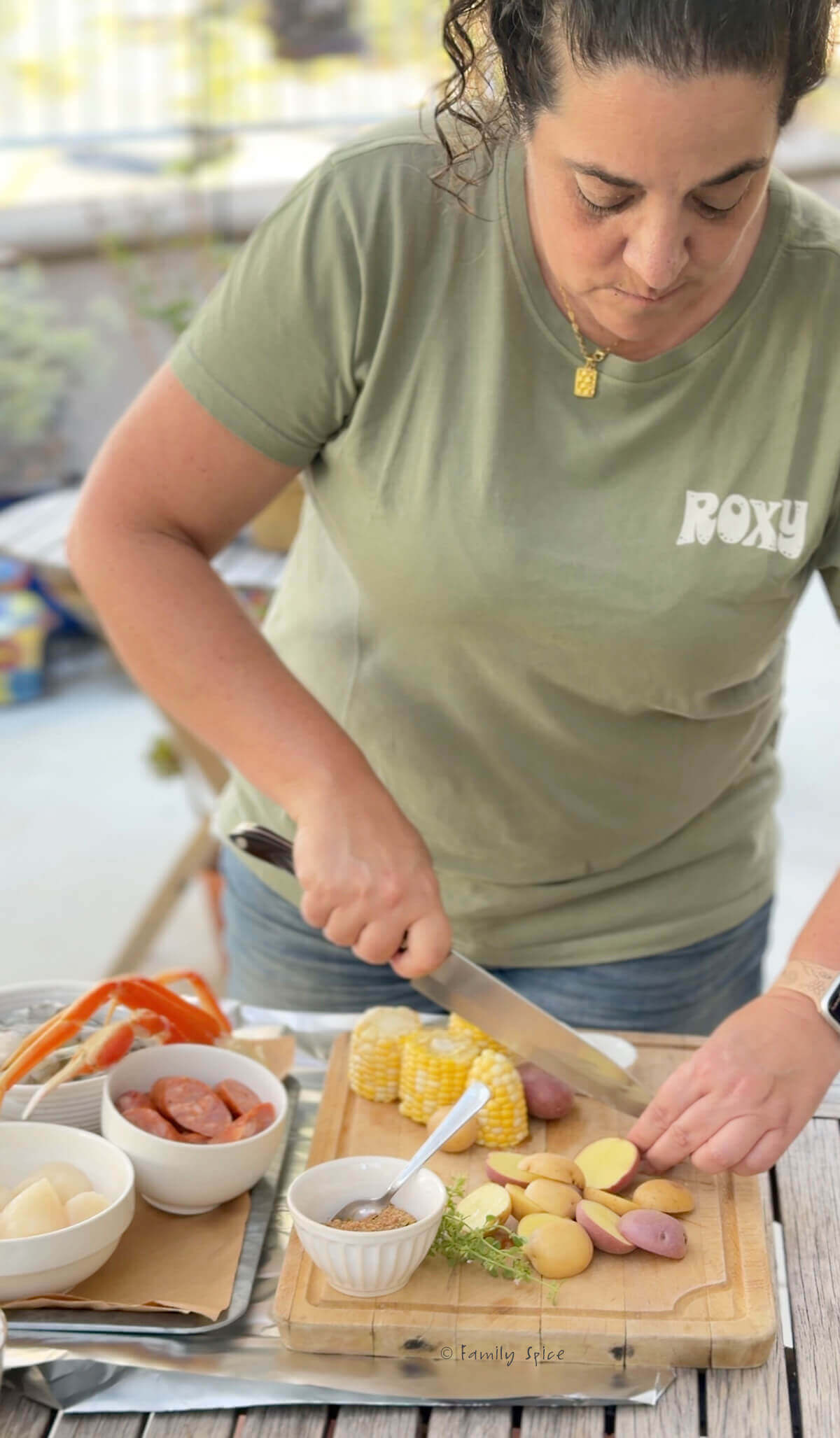 Laura Bashar cutting up potatoes with other ingredients to make seafood foil packet dinners.