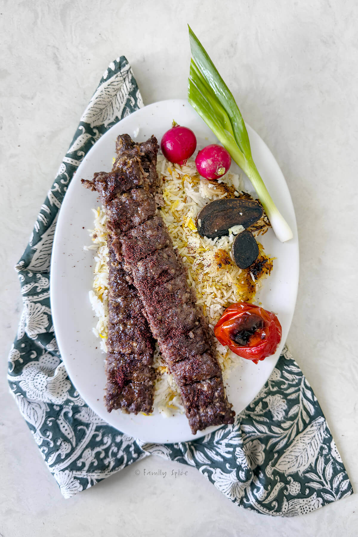 Top view of a plate with oven baked koobideh kabob on basmati rice.