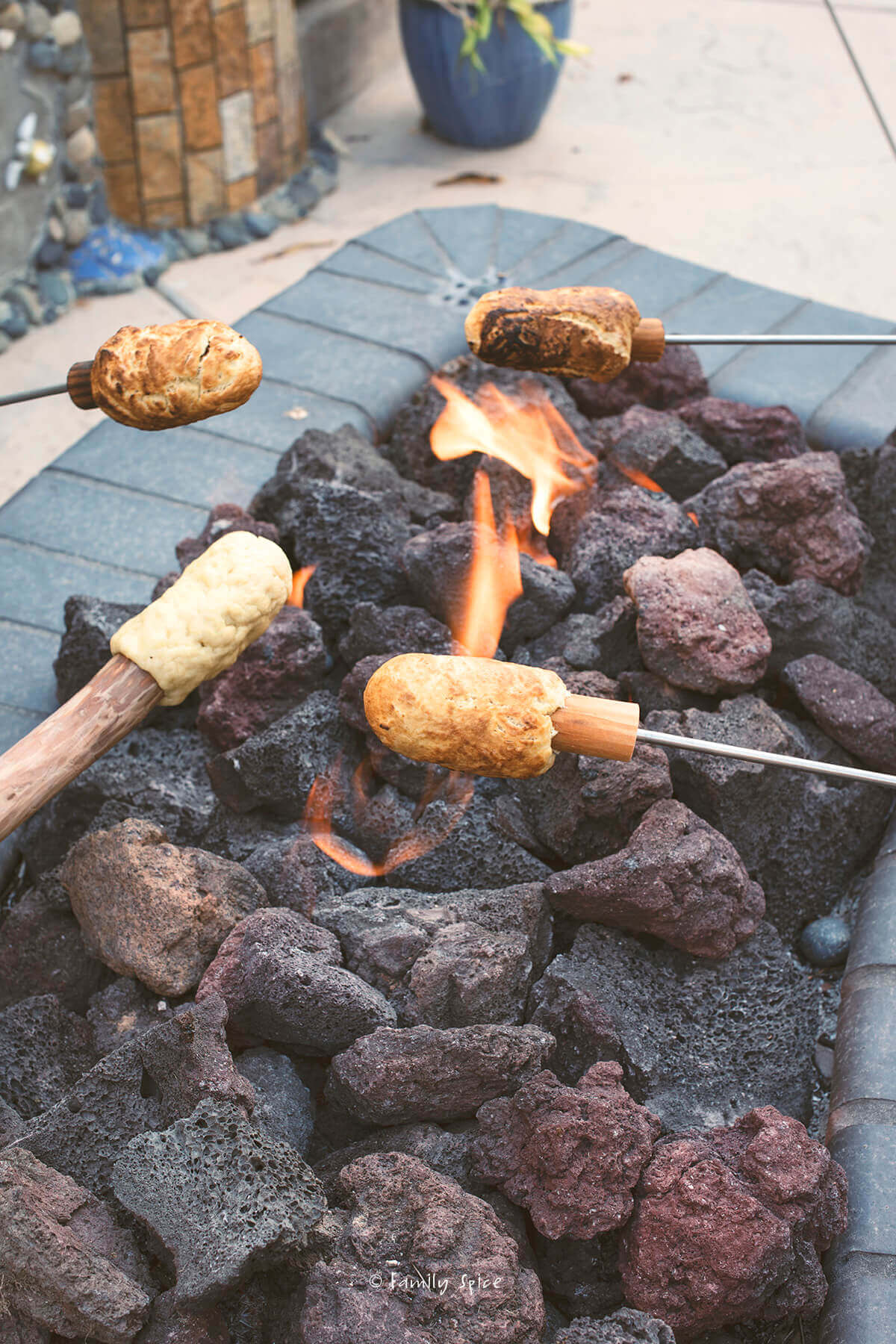 Cooking campfire eclairs over a backyard fire pite