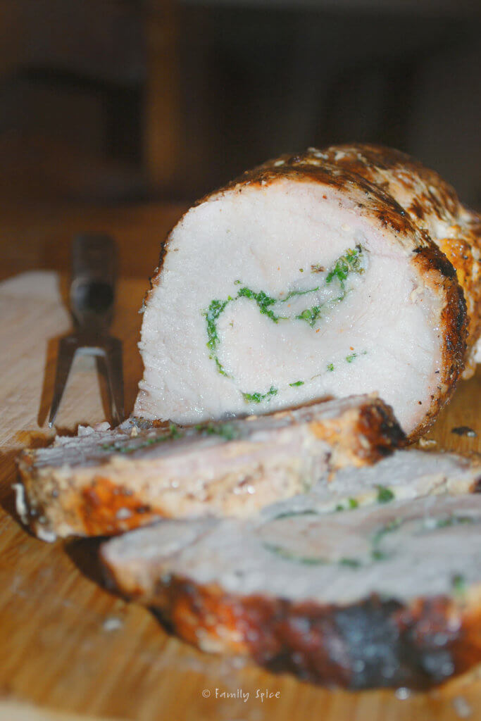 Closeup of a grilled pork loin stuffed with herbs and sliced