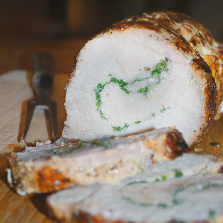 Closeup of a grilled pork loin stuffed with herbs and sliced