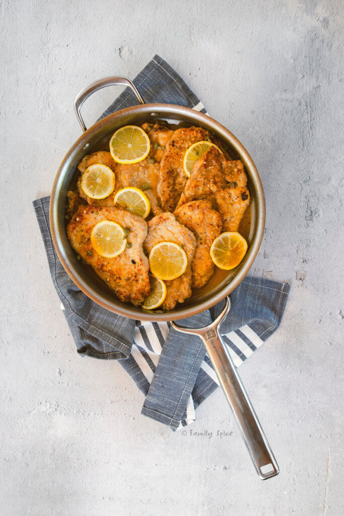 Pork piccata with lemon slices in a large frying pan