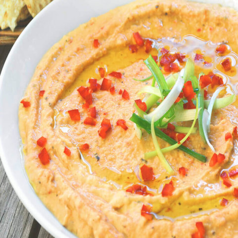 Closeup of a bowl full of roasted red pepper hummus by FamilySpice.com