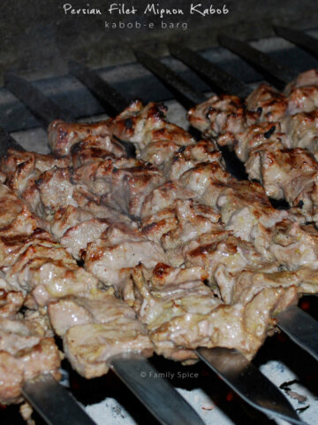 Close up of kabob barg on skewers getting grilled over hot coals by FamilySpice.com