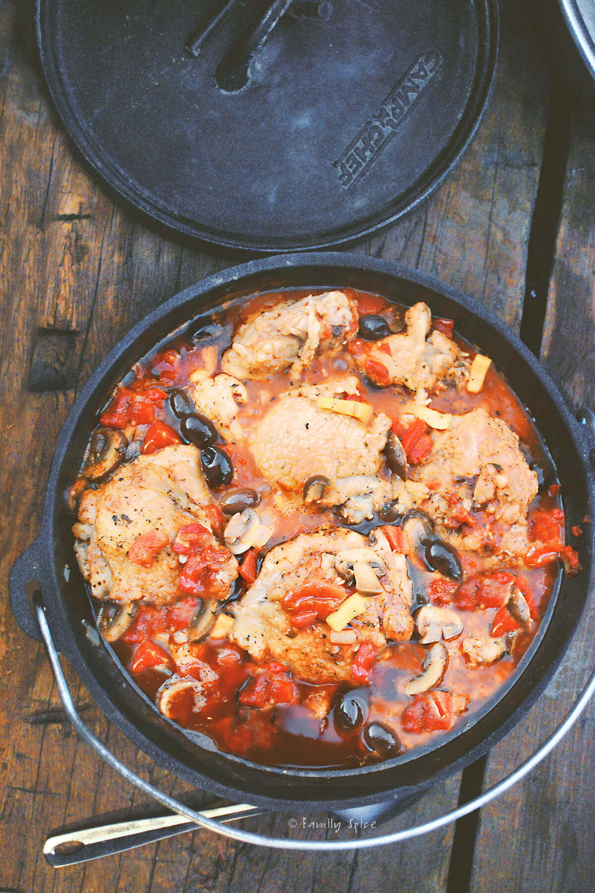 A cast iron Dutch oven with chicken Cacciatore in it