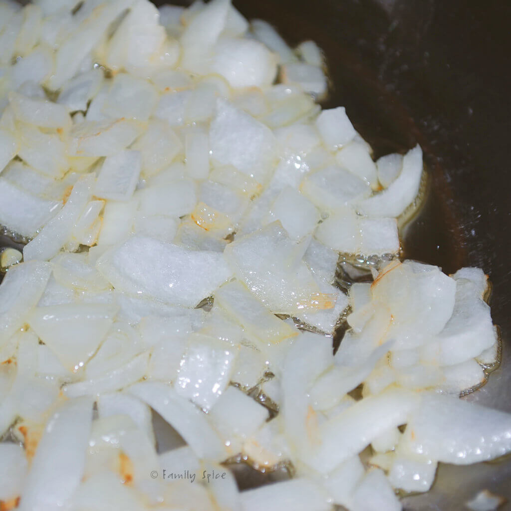 Chopped onions getting sautéd in a pan