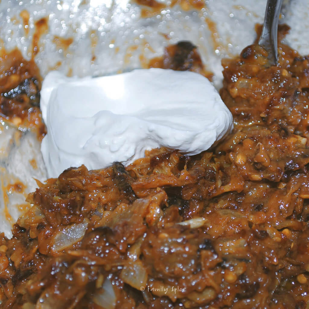 A mixing bowl with mashed eggplant, browned onions and kashk to make kashk bademjan