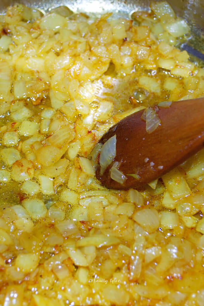 Onions seasoned with turmeric sautéed in a pot