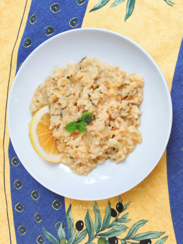 A bowl full of lemon risotto on a blue and yellow tablecloth