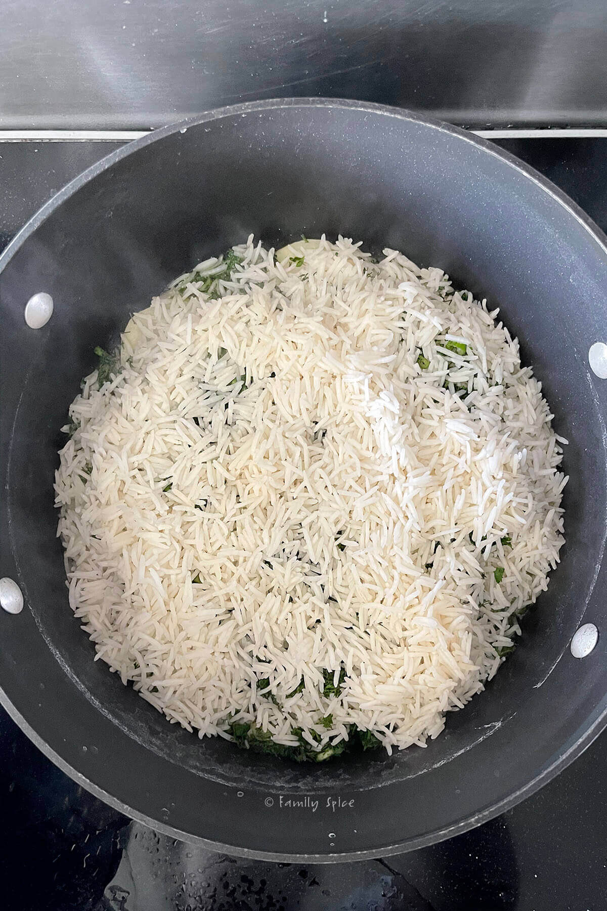 Top view of a non-stick pot with another layer of parboiled rice