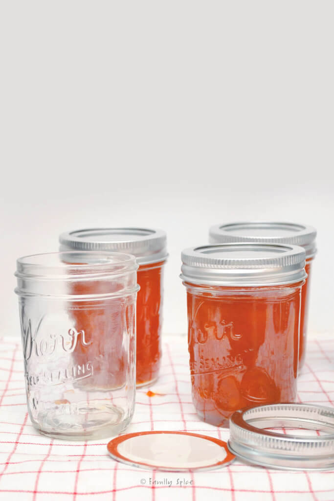 Peach jam in mason jars with empty jar next to it