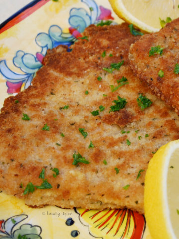 Closeup of a cutlet of pork Milanese on a yellow platter