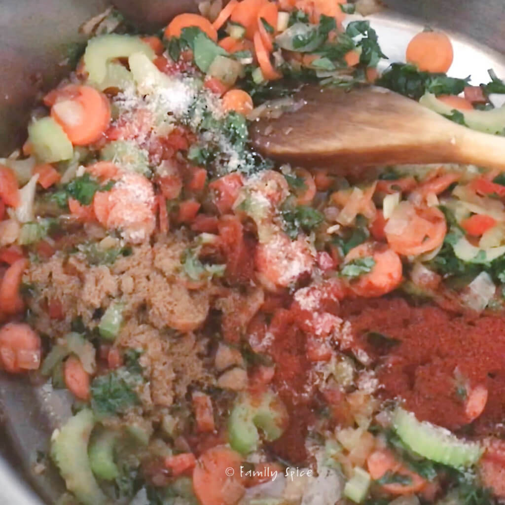 Adding spices to sautéed vegetables to make chicken tortilla soup