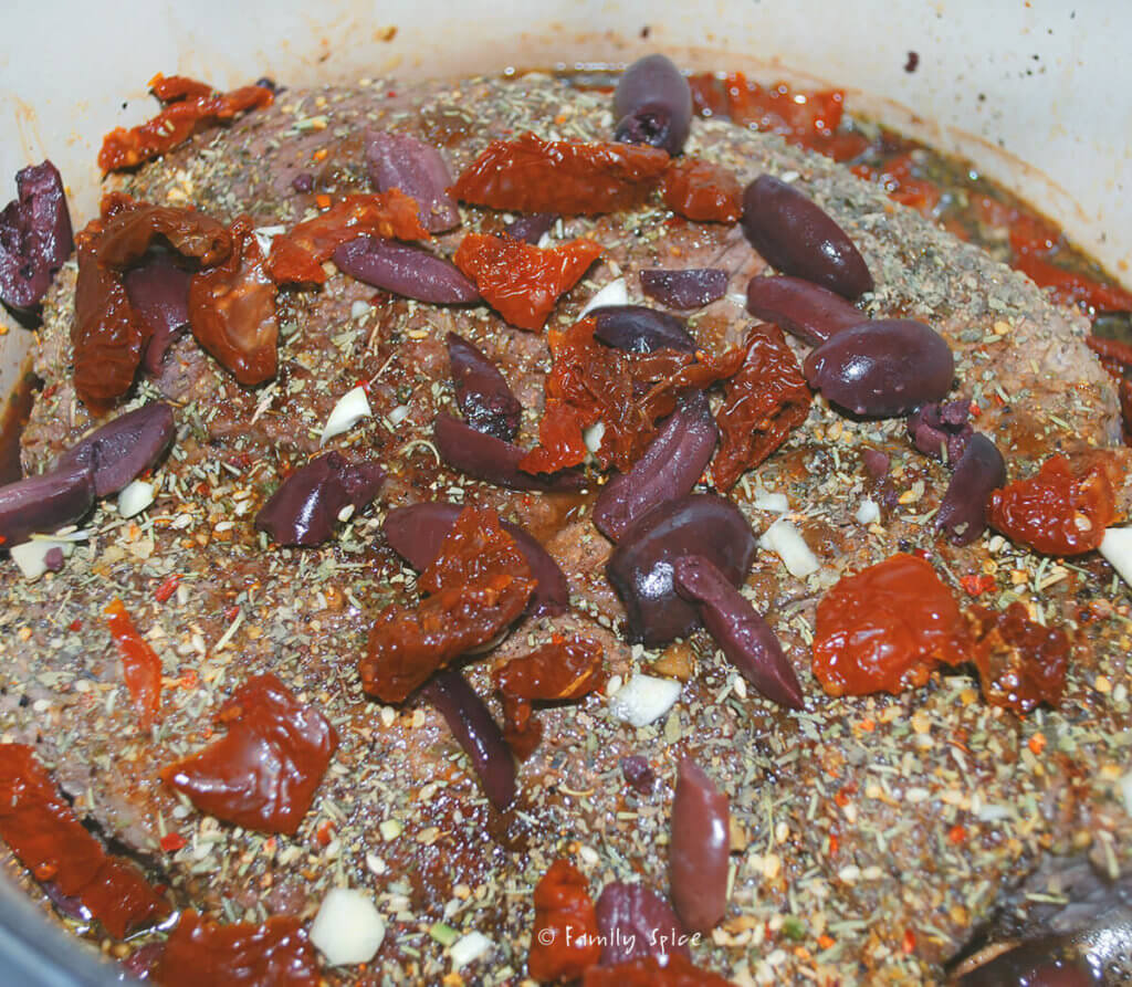 Adding Italian seasonings, sun dried tomatoes and olives into Dutch oven pot roast