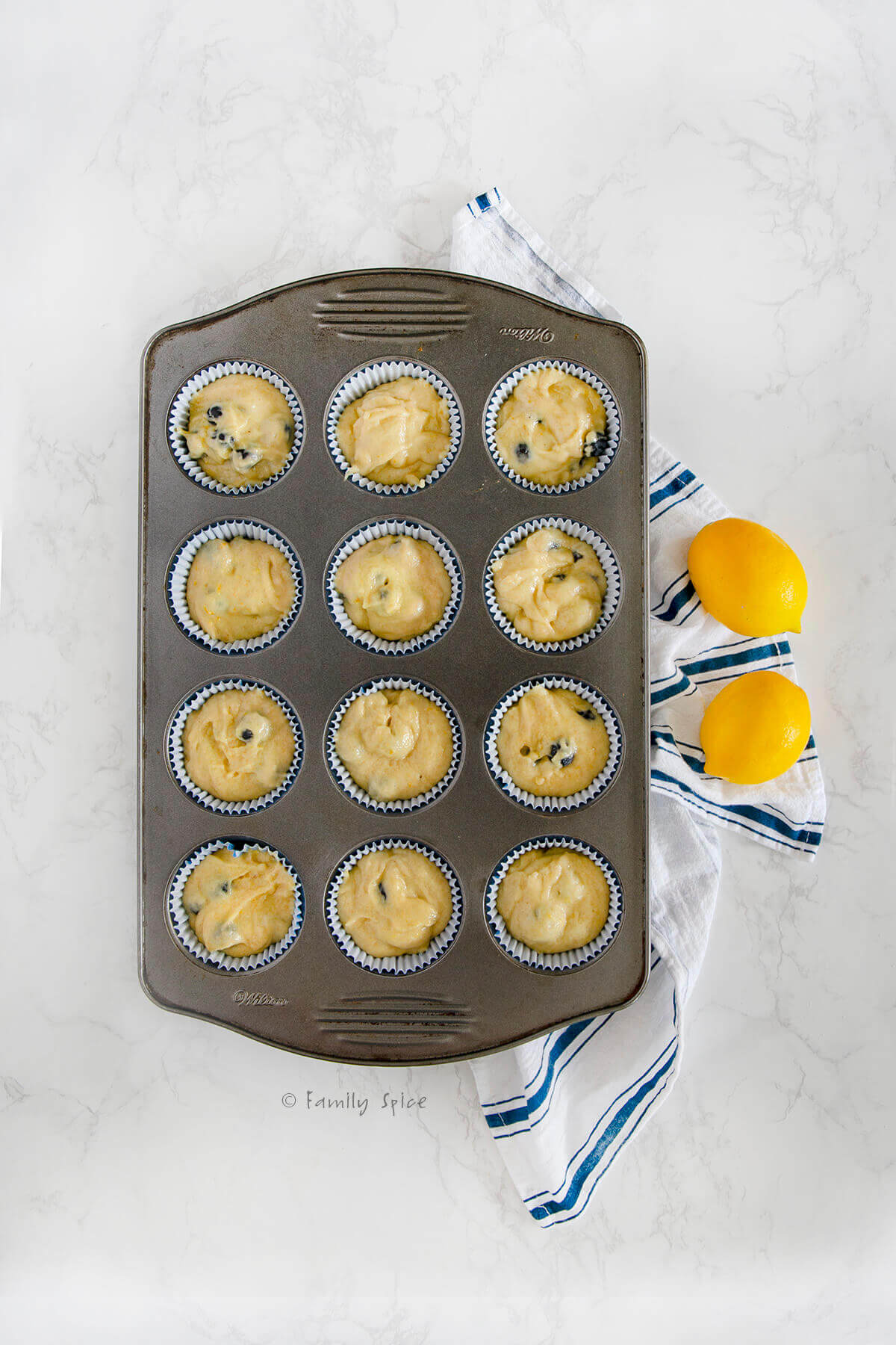 Blueberry muffin batter in cupcake liners in a cupcake pan