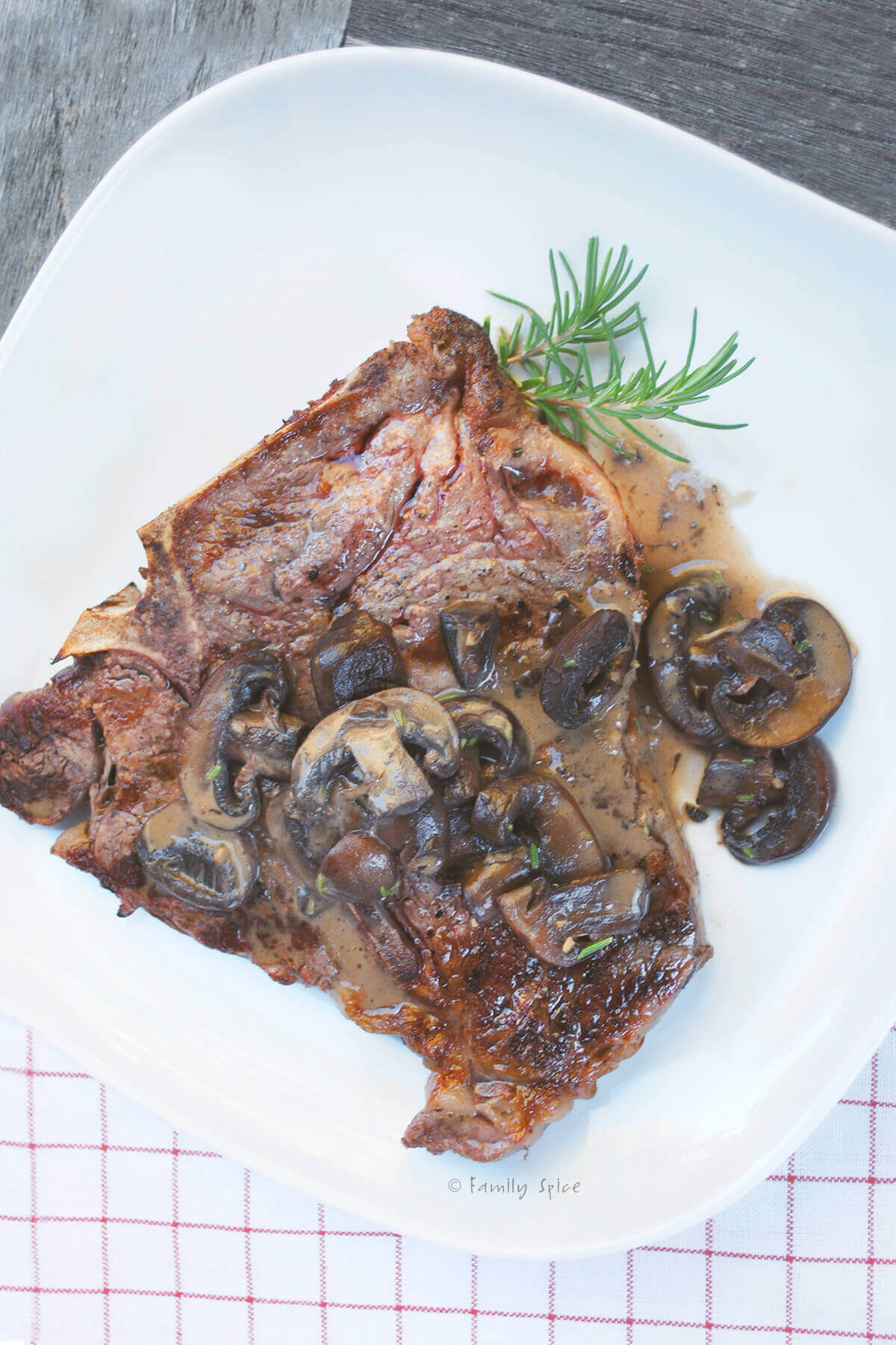 Grilled T-Bone with Creamy Mushroom Sauce on a white plate