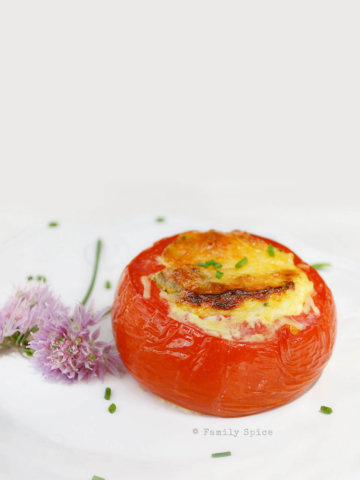Eggs baked in whole tomatoes and topped with cheese and chives