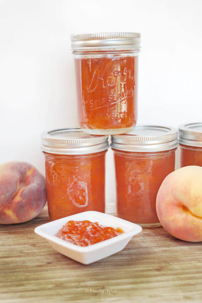 A stack of mason jars filled with peach jam