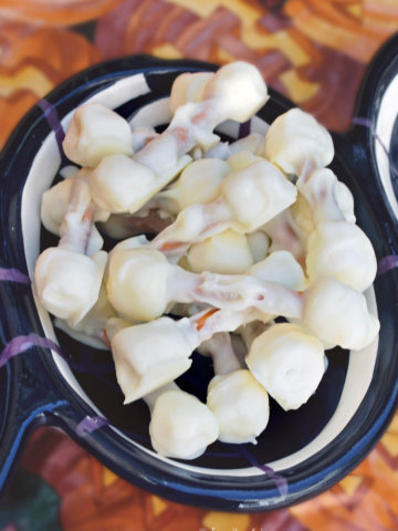 A halloween themed bowl with white chocolate covered edible skeleton bones