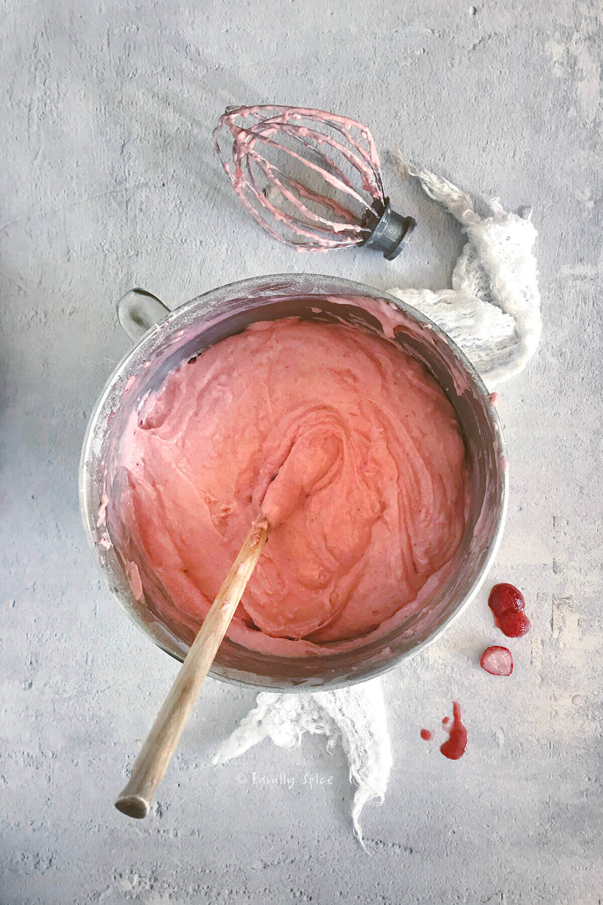 A mixing bowl with pink strawberry cake batter