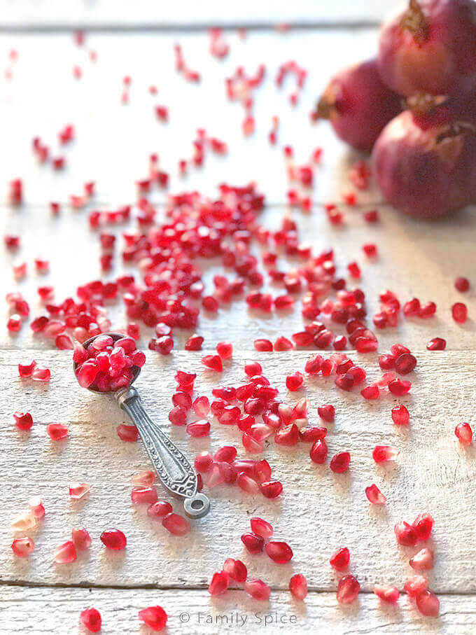 Pomegranate arils spilled on a table by FamilySpice.com