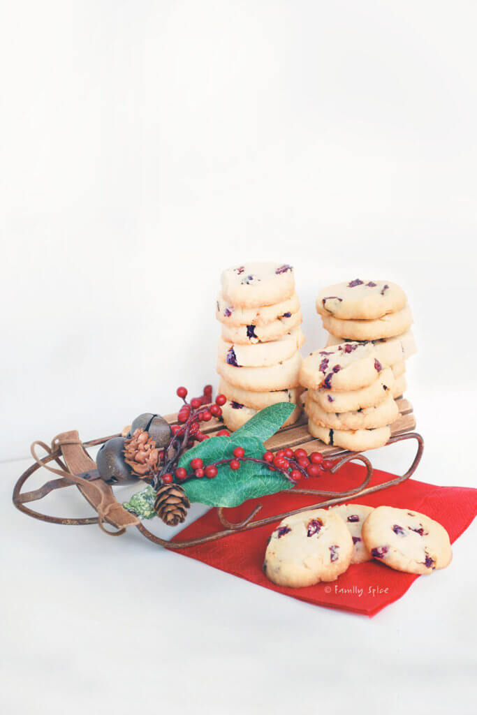 Slices of cherry orange cookies on a mini sleigh and red napkin