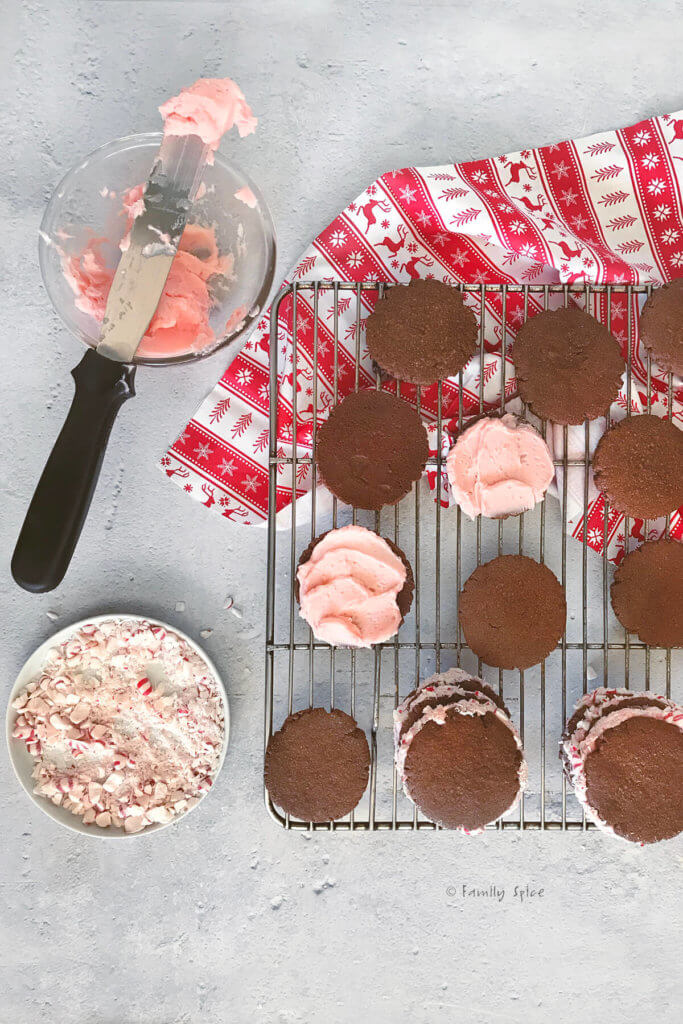 Assembling chocolate sandwich cookies with peppermint frosting