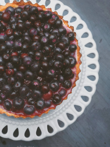 Top view of a blueberry tart on a white serving dish
