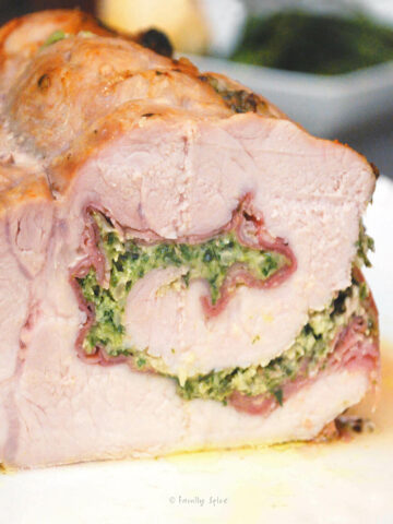 An Italian pork roast rolled and stuffed with pesto and prosciutto on a serving platter