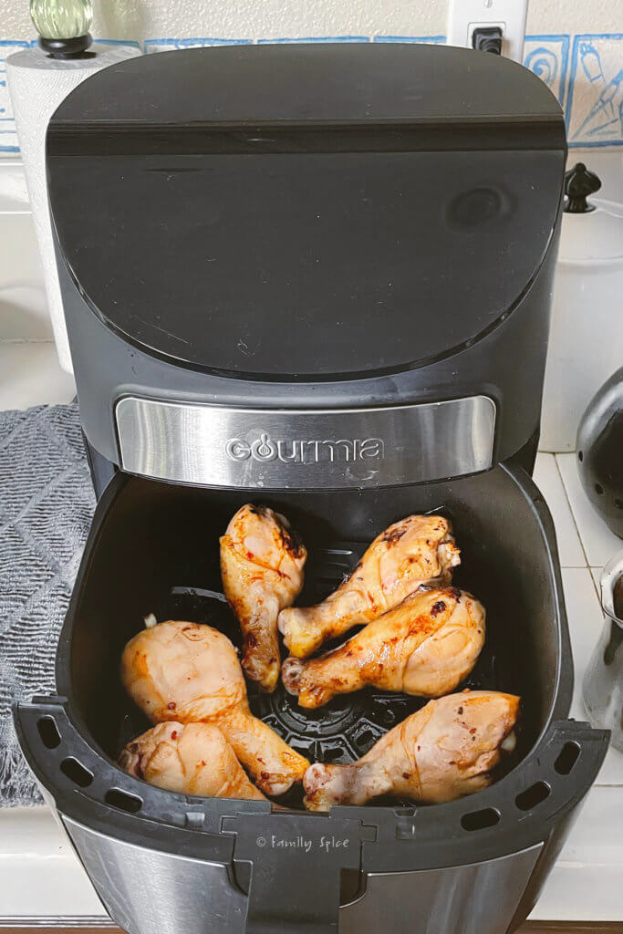 Marinated chicken legs in the air fryer cooked halway