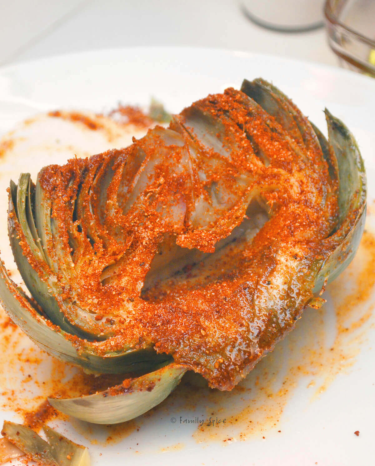 Coating a halved artichoke with chile lime seasoning