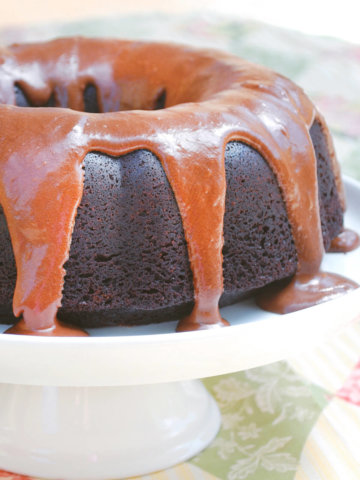 A root beer bundt cake with root beer frosting dripping down on it