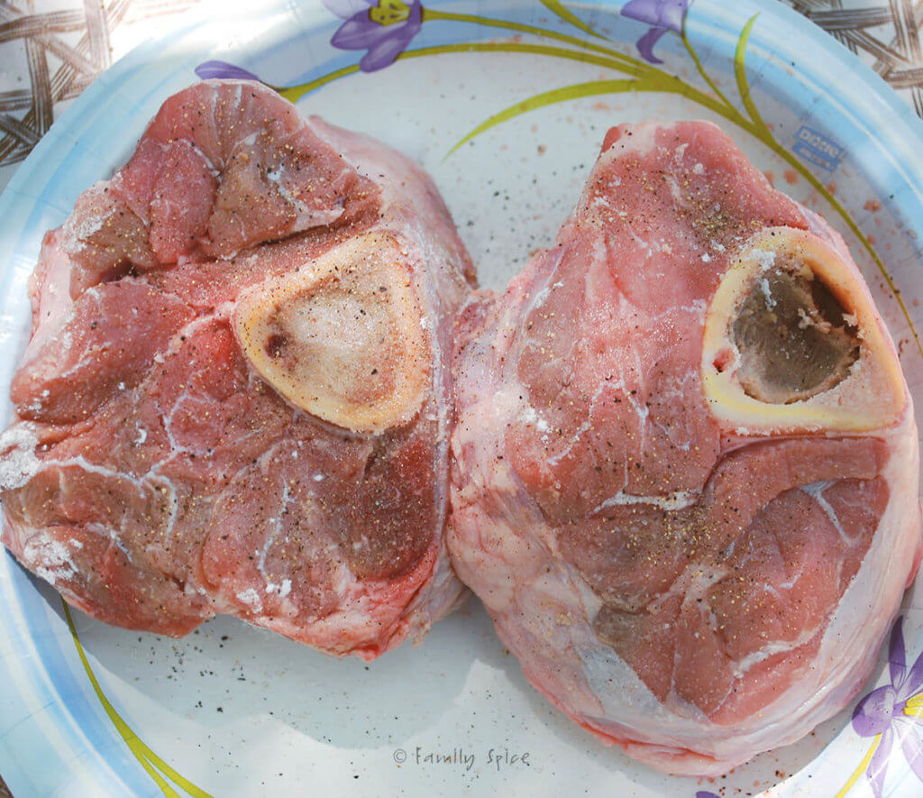 Veal shanks seasoned and on a paper plate