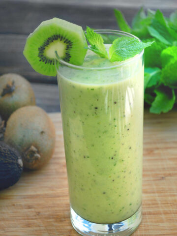 ¾ view of a tall glass with kiwi smoothie in it