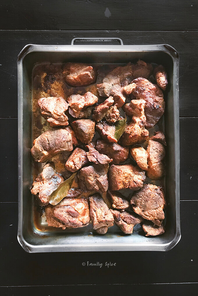 Oven roasted chunks of pork shoulder in a roasting pan by FamilySpice.com