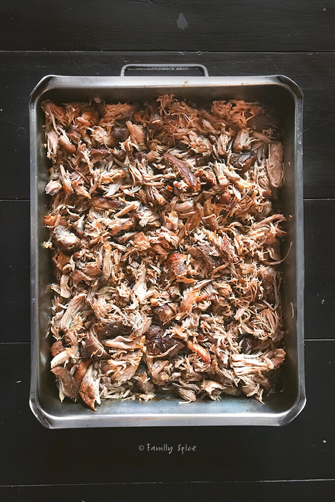 Oven pulled pork shredded in a roasting pan by FamilySpice.com