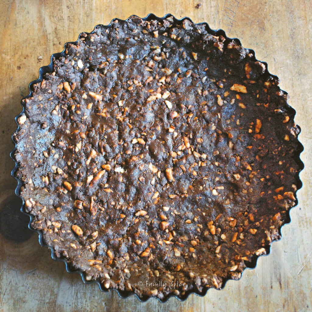 A chocolate pretzel crust pressed into a tart pan