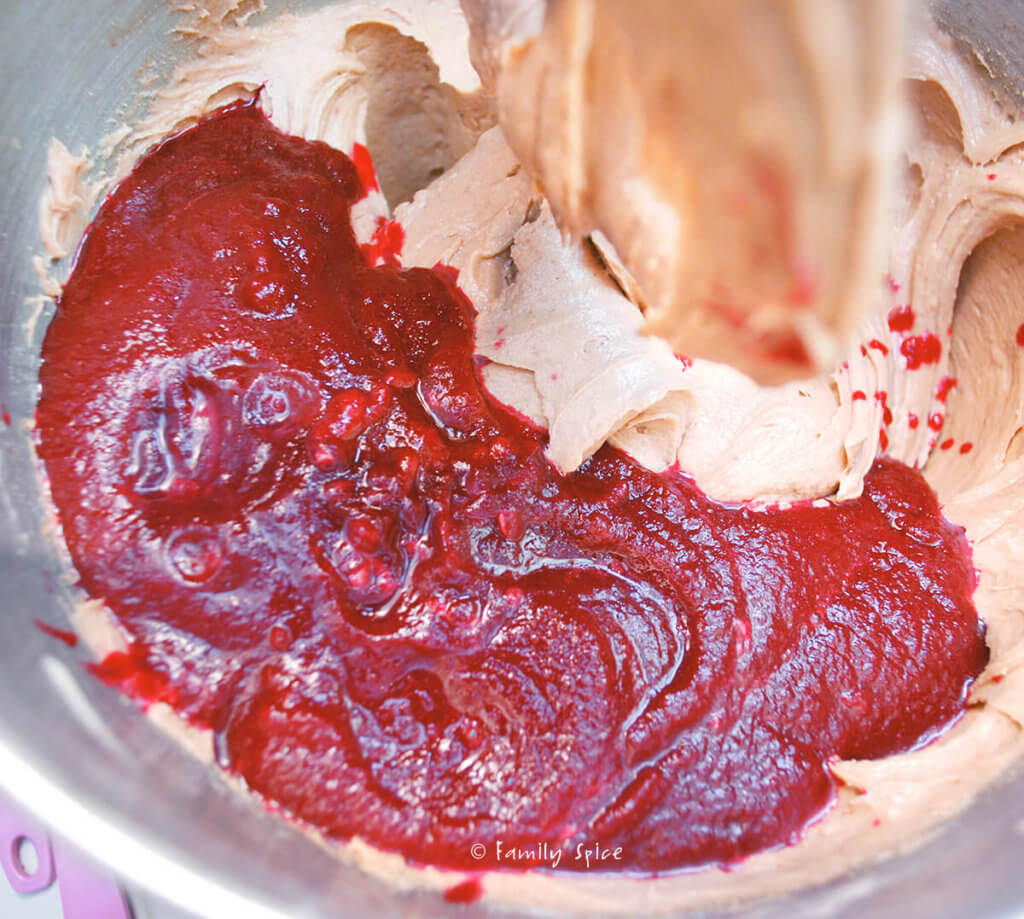 Puréed beet mixture added to cake batter in a mixing bowl