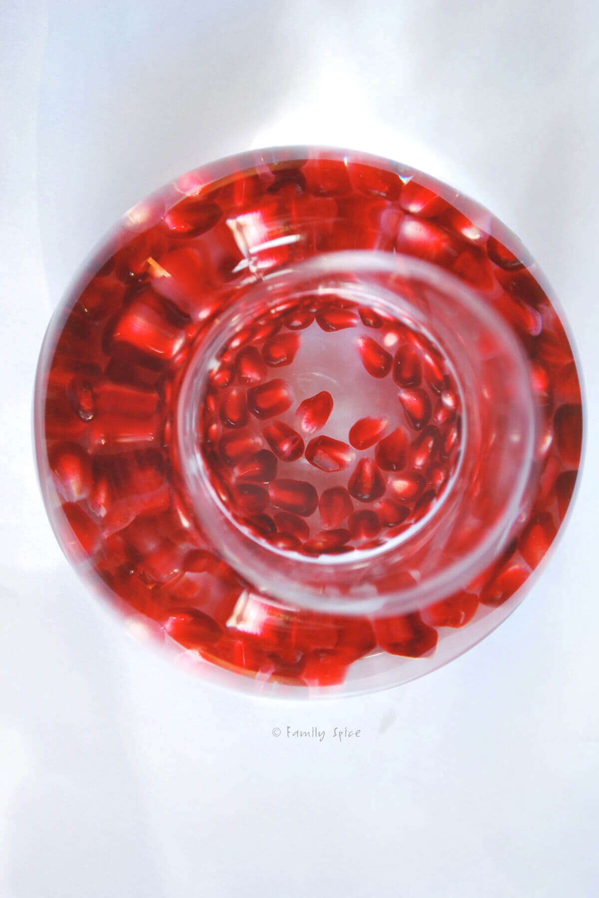 Top view of pomegranate arils in a bottle of vodka