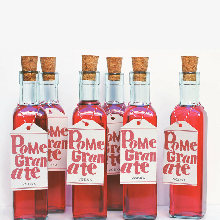 Several bottles of homemade pomegranate vodka with free printable labels