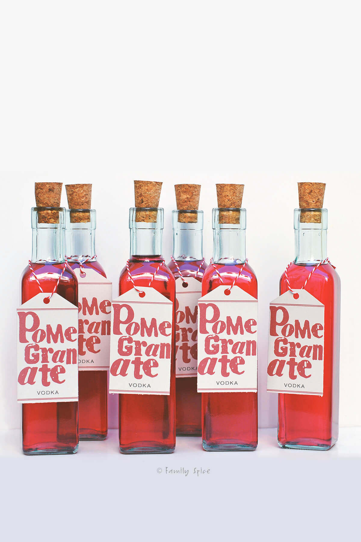 Several bottles of homemade pomegranate vodka with free printable labels