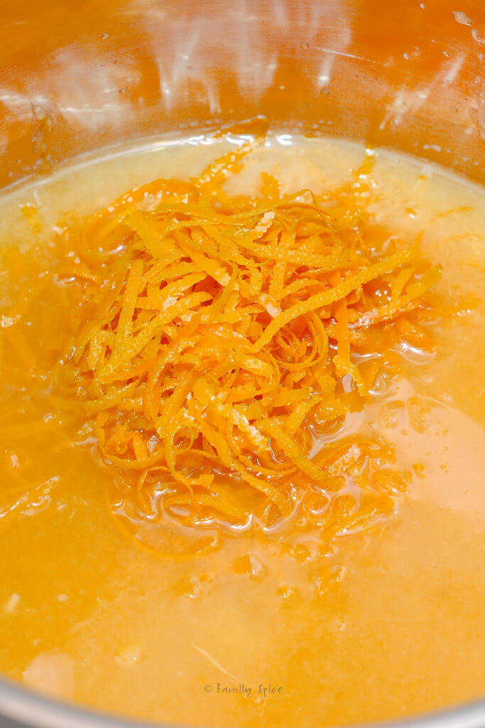 Making orange jam in a pot using orange juice, orange zest and sugar