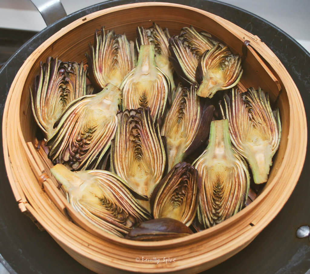 Baby purple artichokes halved and steamed in a steamer basket
